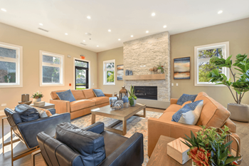 Spacious community lounge with fireplace and orange sofas